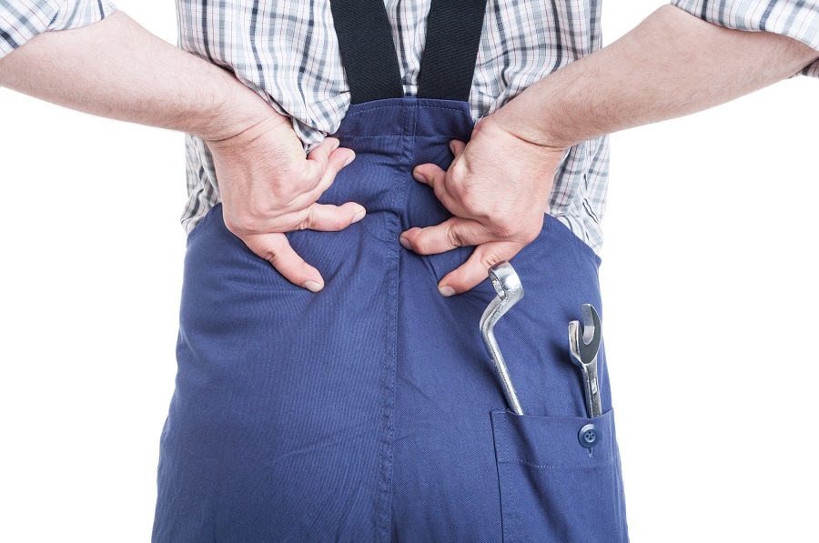 Workers Compensation Claims arise from a mechanic constantly bending over to work on cars. This mechanic is rubbing his injured aching back.